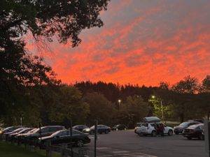 The sun sets over Hinman parking lot as a student’s family helps them unpack so they can move into their dorm.